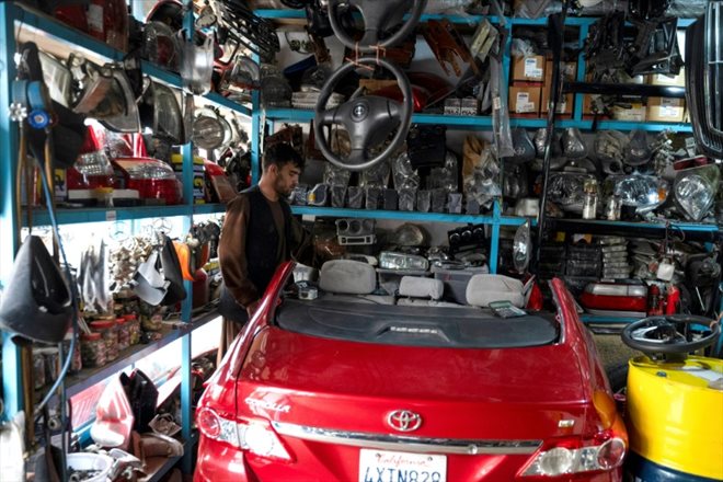 Un vendeur prépare une Toyota Corolla dans sa boutique de pièces détachées, le 27 avril 2023 à Kaboul, en Afghanistan