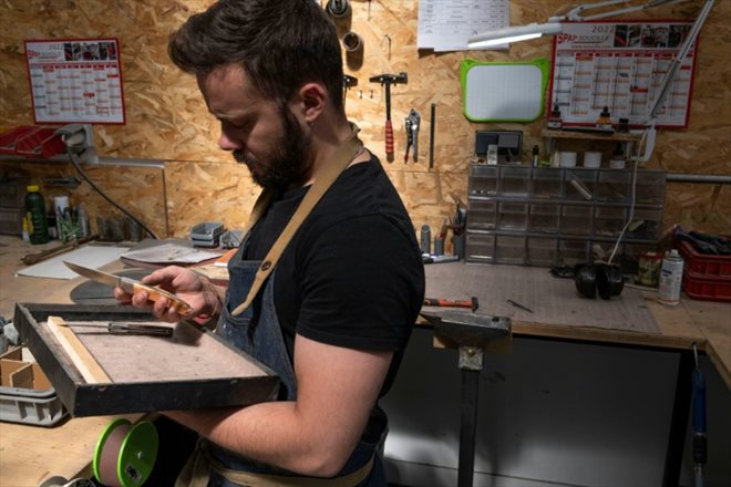 Un employé contrôle les finitions d'un couteau traditionnel Laguiole à la coutellerie Fontenille Pataud, le 12 mai 2022 à Thiers