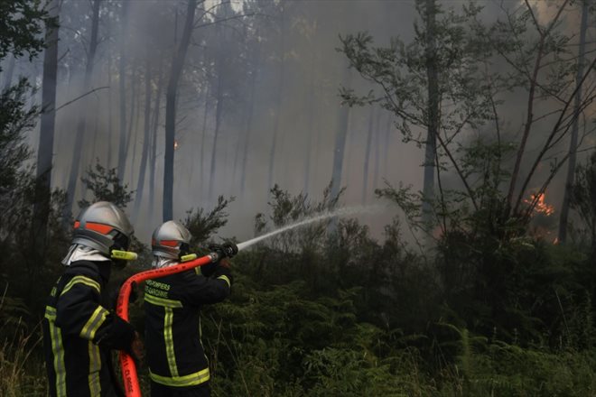 Des pompiers tentent de circonscrire un incendie, le 17 juillet 2022 à Louchats (Gironde)