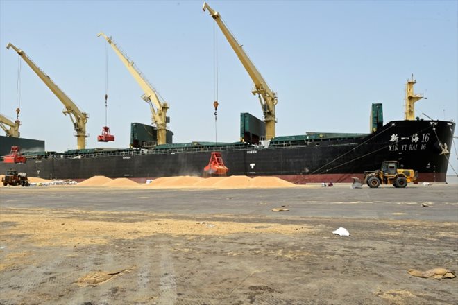 Des grues chargent du blé à bord d'un bateau, le 18 mai 2022 dans le port de Kandla, en Inde
