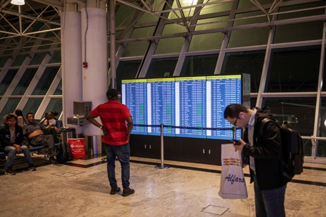 Un voyageur regarde un tableau d'information sur les vols à l'aéroport d'Addis Abeba, le 5 février 2024 en Ethiopie