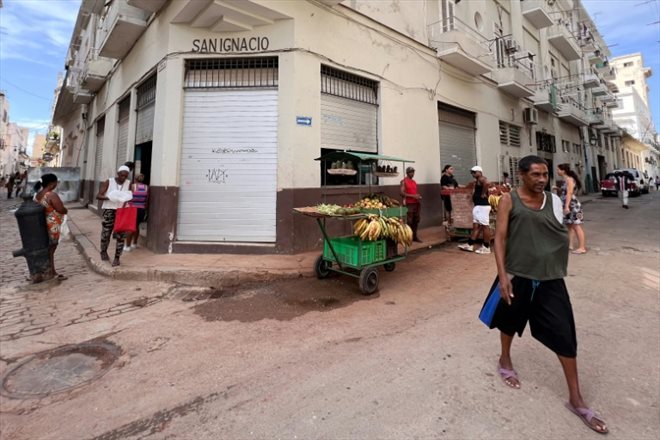 Des Cubains attendent de recevoir une ration d'aliments subventionnés devant une bodega de La Havane, le 17 septembre 2024