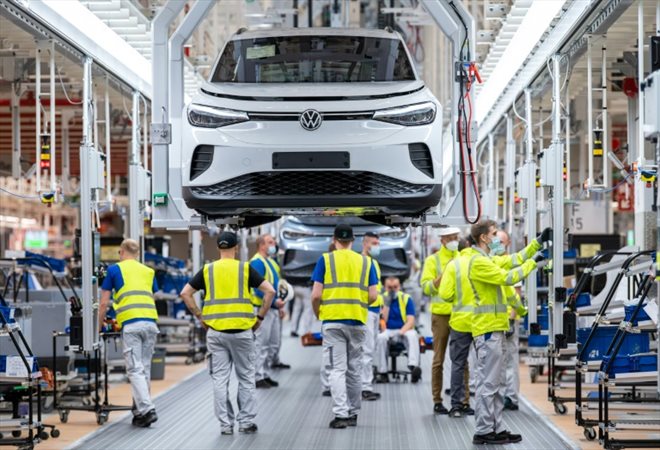 Photo du 20 mai 2022 montrant des ouvriers d'une ligne d'assemblage de Volkswagen ID4 électriques à l'usine d'Emden, dans le nord de l'Allemagne