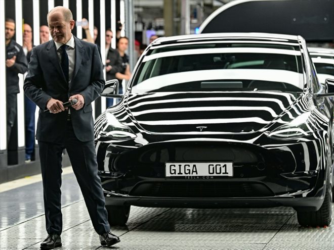  Le chancelier allemand Olaf Scholz pose près d'une voiture électrique du fabricant américain Tesla, qui vient faire concurrence aux marques allemandes avec une usine géante près de Berlin, le 22 mars 2022