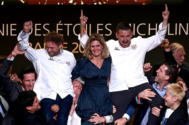 Les chefs français Arnaud Donckele (g) et Dimitri Droisneau (d), accompagné de son épouse Marielle Droisneau (c), célèbrent leur 3e étoile respective au guide Michelin au théâtre de l'Avant Scène à Cognac, en Charente, le 22 mars 2022