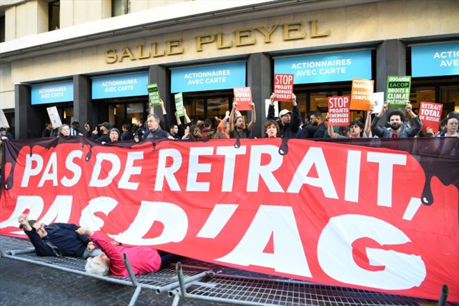 Des militants d'ONG environnementales à l'entrée de la salle Pleyel où se tient l'assemblée générale des actionnaires de TotalEnergies, le 25 mai 2022