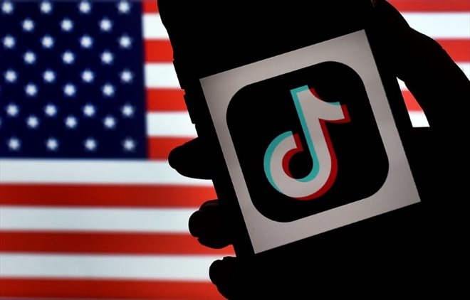 Le logo de TikTok sur un téléphone, avec un drapeau américain en fond, le 3 août 2020 à Arlington