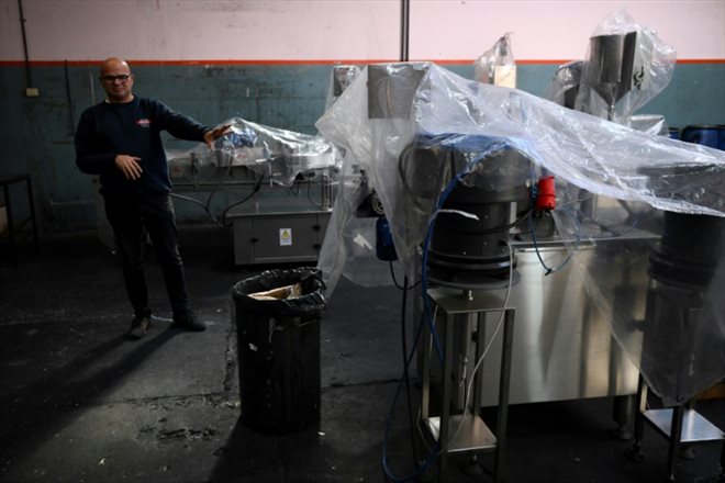 Gustavo Avalos, patron de l'usine Tintas Opalo, à côté de ses machines-emballeuses flambant neuves, lors d'une interview avec l'AFP, le 17 avril 2024 à Sarandi, dans la province de Buenos Aires, en Argentine