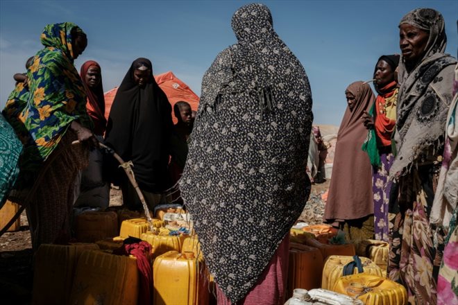 Des femmes rassemblées pour une distribution d'eau dans le camp de déplacés de Muuri à Baidoa (Somalie) le 13 février 2022