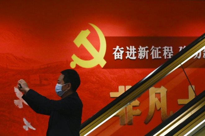 Un homme prend une photo dans un centre de presse en marge du 20e congrès du Parti communiste chinois, à Pékin, le 20 octobre 2022