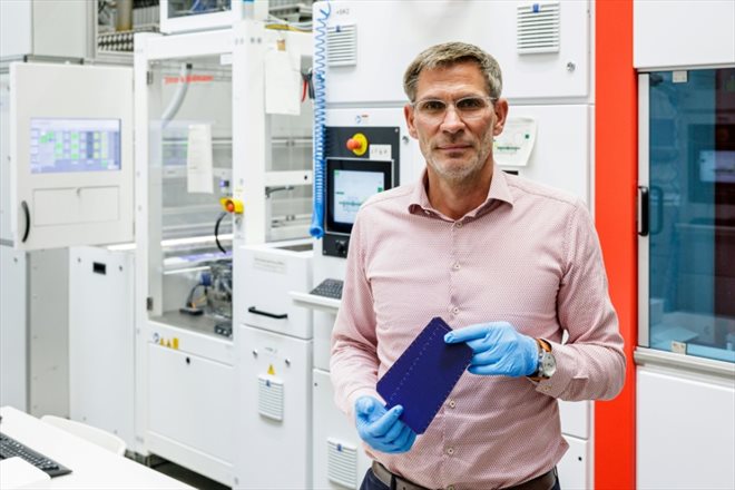 Jochen Fritsche, le directeur de l'usine du groupe suisse Meyer Burger,  devant une machine produisant des cellules solaires, le 26 septembre 2023 à Bitterfeld-Wolfen, dans l'est de l'Allemagne