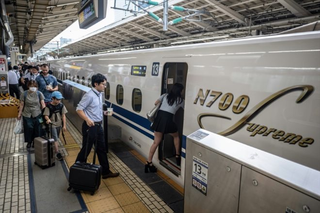 Des passagers montent à bord d'un train à grande vitesse Shinkansen, à la gare de Tokyo, le 25 juillet 2024