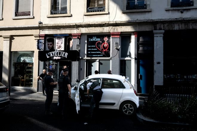 Des policiers fouillent une voiture devant un bar à chicha lors de l'Opération Colbert de lutte contre le trafic de tabac, le 1er juin 2023 à Lyon