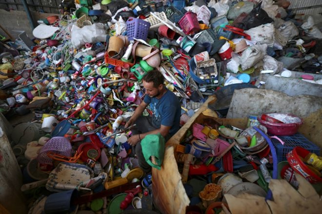 Un travailleur palestinien trie des produits en plastique dans un atelier dans le nord de la bande de Gaza, le 23 août 2022