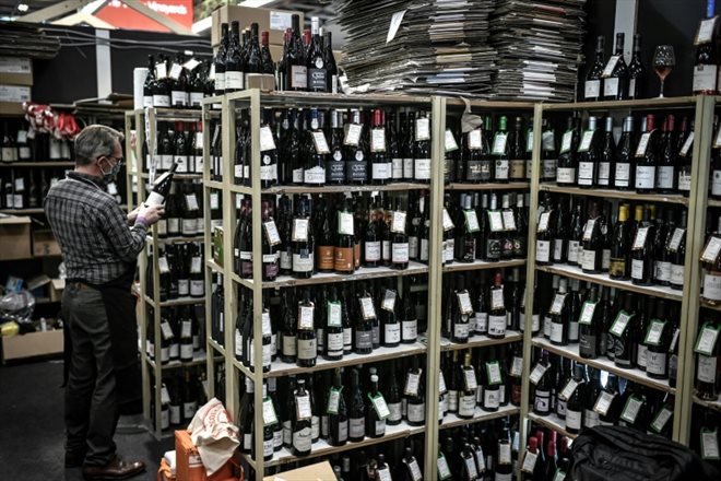 Un exposant examine une bouteille de vin lors du salon Wine Paris et Vinexpo Paris, le 14 février 2022