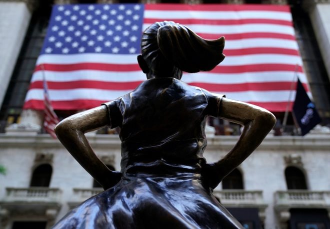 La statue de l'artiste Kristen Visbal devant la façade du New York Stock Exchange