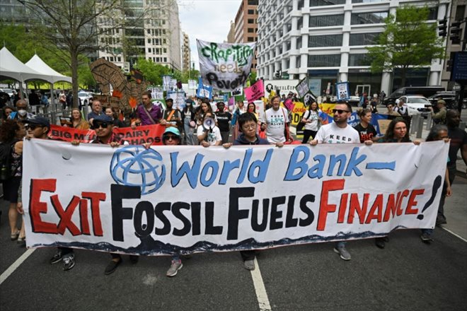 Des militants de la lutte contre le changement climatique manifestent vendredi devant le siège de la Banque Mondiale à Washington