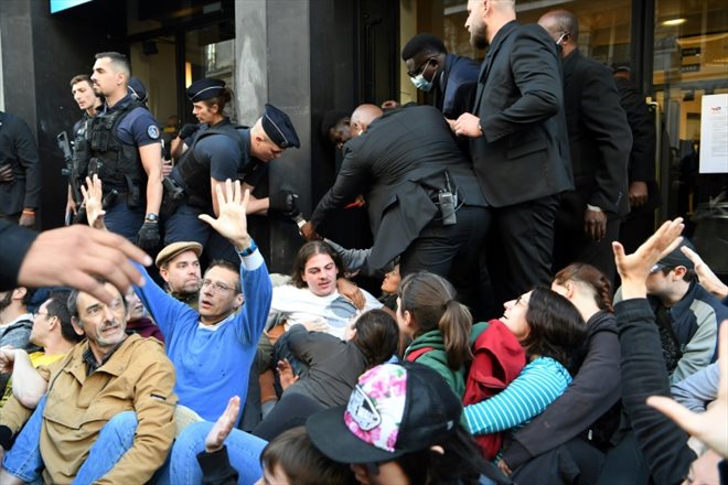 Des manifestants bloquent l'accès de la salle où doit se tenir l'Assemblée générale de TotalEnergies, le 25 mai 2022 à Paris