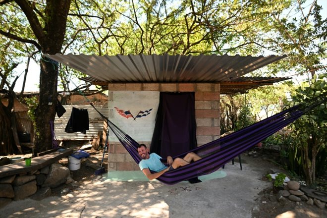 L'Américain Corbin Keegan dans un hamac dans la cour d'une maison de pêcheur à Playa Blanca, le 11 janvier 2024 au Salvador