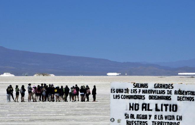 Des touristes visitent le désert de sel de Salinas Grandes près d'un panneau anti-lithium dans la province septentrionale de Jujuy, en Argentine, le 18 octobre 2022