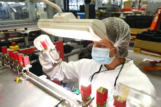 Une employée de la société L'Oréal contrôle la qualité de cosmétiques sur une chaîne de production à Lassigny, dans le nord de la France, le 6 octobre 2021