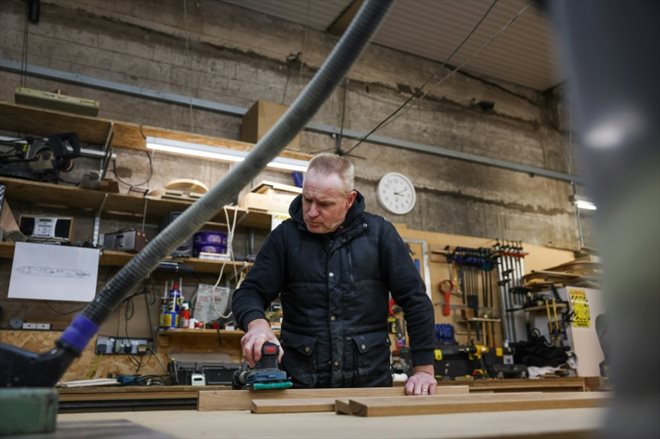 Un menuisier travaille sur des planches en bois pour une péniche hybride dans l'atelier de l'Ortomarine, une entreprise spécialisée dans la construction de péniches électriques, le 25 janvier 2024 dans le Worcestershire