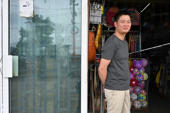 Un commerçant chinois originaire du Fujian devant un magasin à Port Moresby, le 20 mai 2023
