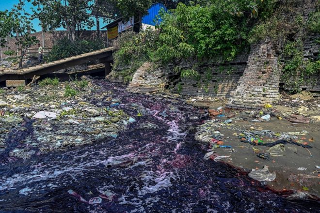 Un cours d'eau de couleur cramoisie s'écoule de canaux stagnants d'une usine, le 6 mars 2022 à Narayanganj, au Bangladesh
