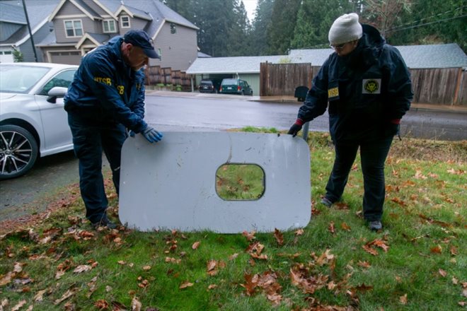 Photo de la NTSB montrant des agents inspectant le 8 janvier 2024 une porte tombée d'un avion d'Alaska Airlines, à Portland aux Etats-Unis