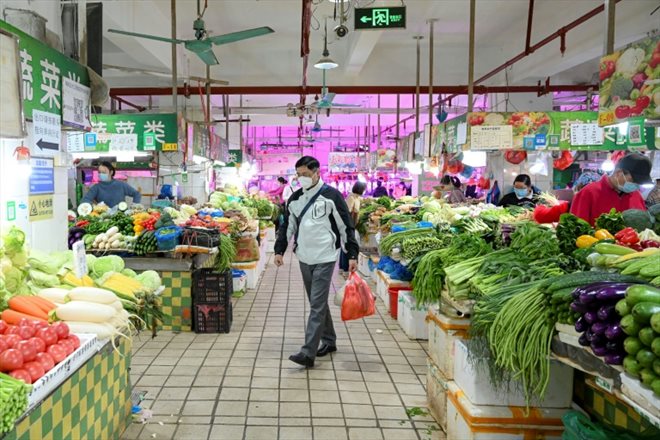 Un homme fait ses courses sur un marché de Canton, dans le sud de la Chine, le 1er décembre 2022