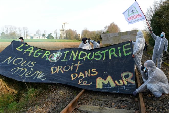 Des membres du collectif Bretagne contre les fermes usines bloquent une voie ferrée pour empêcher un train transportant des céréales de passer, le 19 mars 2022 près de Pontivy, en Bretagne