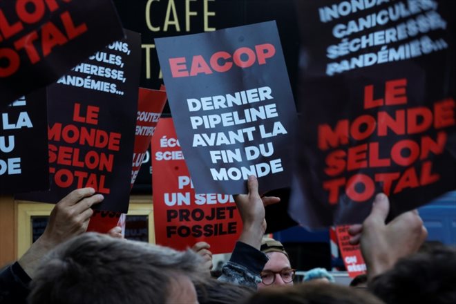 Des manifestants pour le climat aux abords de la salle parisienne où doit se dérouler l'assemblée générale annuelle de TotalEnergies, le 26 mai 2023, à Paris