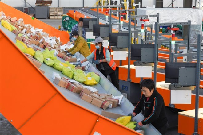 Des employés d'un centre logistique trient les colis pour la Fête des célibataires, énorm opération de soldes en Chine, le 10 novembre à Zouping, dans la province de Shandong (est)