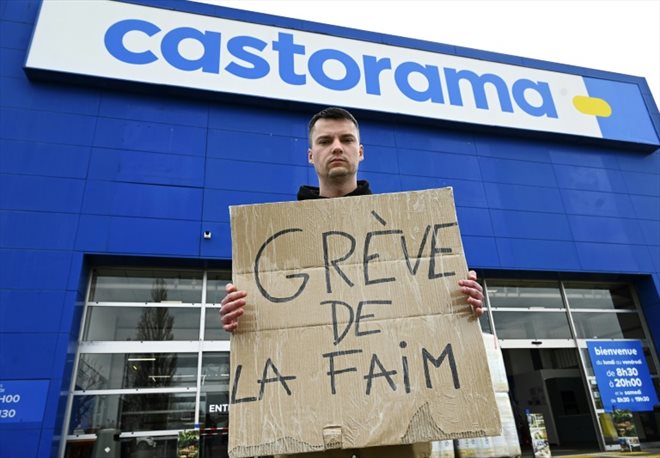 Xavier Gaspard, vendeur chez Castorama, tient une pancarte où il revendique sa grève de la faim, le 17 mars 2023 devant le magasin de Lampertheim, dans le Bas-Rhin