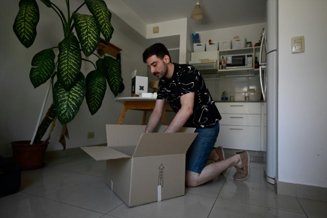 Tomas Sislian remplit des cartons alors qu'il se prépare à déménager d'un appartement loué, poussé par la crise immobilière en Argentine, le 8 janvier 2023 à Buenos Aires