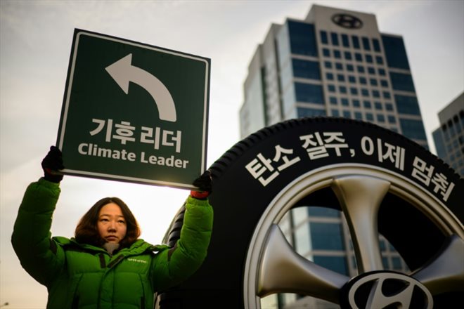 Une militante de Greenpeace lors d'une action de protestation contre les SUV devant le siège du géant automobile sud-coréen Hyundai à Séoul le 29 novembre 2023