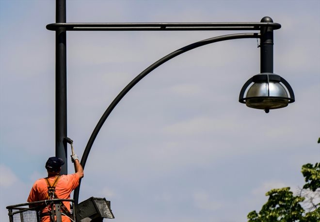 Un homme repeint un lampadaire, à Berlin, le 8 juin 2023