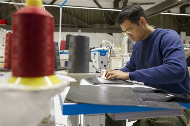 Davy Dao, fondateur de la marque textile Dao, coud un sac en cuir végétal de lin au siège de l'entreprise à Maxeville, le 23 novembre 2023 en Meurthe-et-Moselle