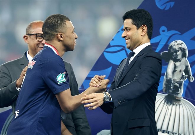 Kylian Mbappé serre la main du président du PSG Nasser Al-Khelaifi (R) après la victoire du club parisien en finale de la Coupe de France face à Lyon, à Villeneuve d'Ascq, le 25 mai 2024