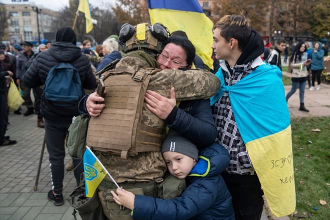 Des habitants de Kherson fêtent la libération de leur ville après le retrait des troupes russes, le 13 novembre 2022 dans le sud de l'Ukraine