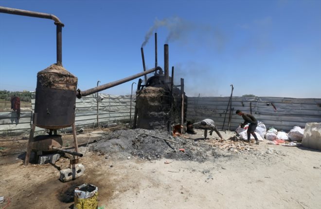 Un réservoir relié à une cuve permet l'extraction de carburant de produits en plastique dans la bande de Gaza, le 23 août 2022