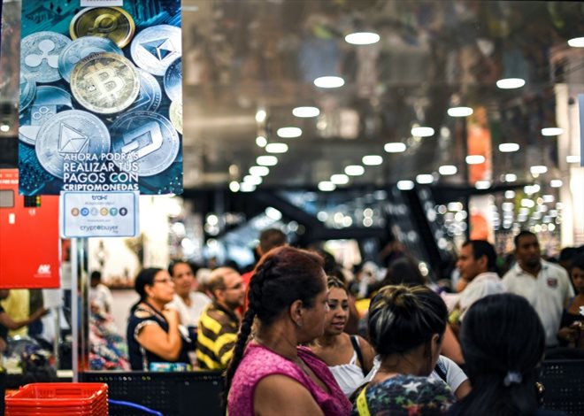 Des clients font la queue devant les caisses d'un magasin qui accepte la cryptomonnaie vénézuélienne Petro, le 28 décembre 2019 à Caracas