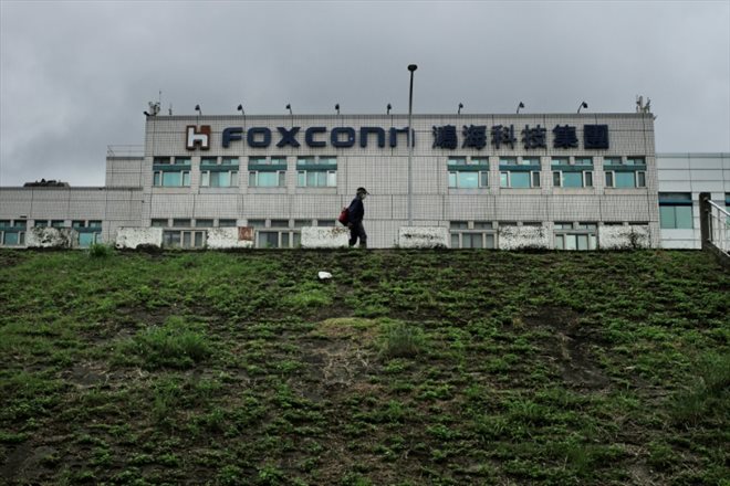 Cette photo d'archive prise le 6 mai 2022 montre un homme passant devant le siège de Foxconn dans le district de Tucheng, à New Taipei City