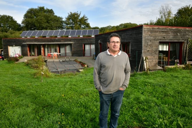 L'ingénieur à la retraite Jean Chappert pose à côté de sa maison autonome en énergie conçue par lui-même, qui n'est reliée à aucun réseau électrique, à Saint-Priest-La-Plaine, en Creuse, le 19 octobre 2022