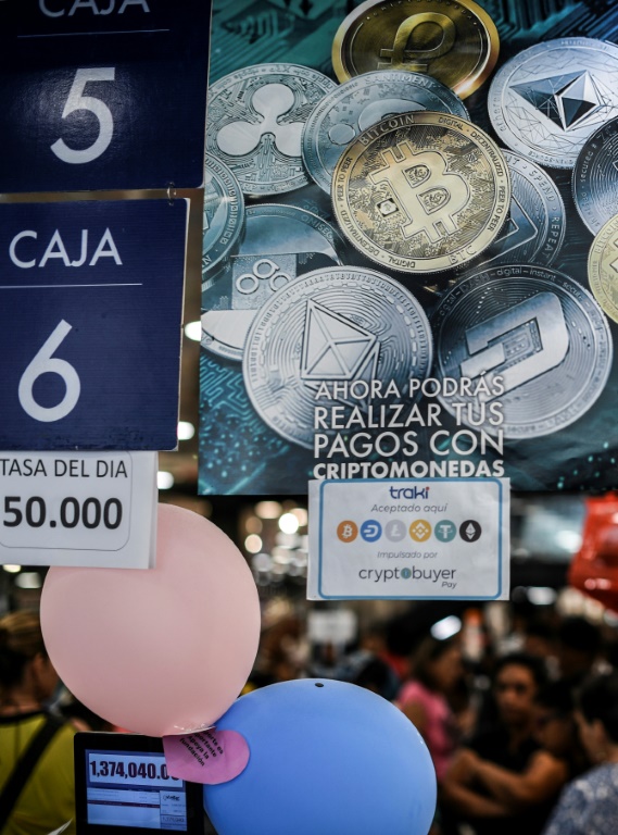 Une affiche indique que les paiements peuvent être effectués avec des cryptomonnaies, faisant référence à la cryptomonnaie vénézuélienne Petro, dans un magasin de Caracas, le 28 décembre 2019