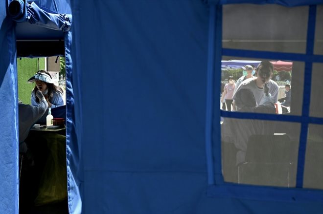 Des habitants se font dépister au Covid-19, le 18 mai 2022 à Pékin