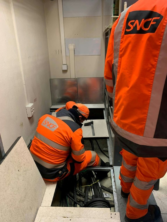 Des employés de la SNCF travaillant sur des câbles vandalisés près de Vaires, à l'est de de Paris, le 24 janvier 2023