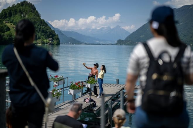 Des touristes font des selfies sur une petite jetée en bois rendue célèbre par une série Netflix sud-coréenne, le 2 juin 2023 à Iseltwald, en Suisse