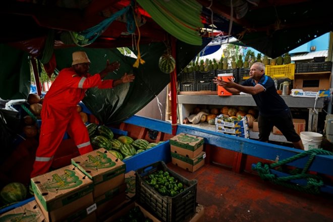 Le marchand vénézuélien José Laclé arrange des fruits sur le marché flottant de Willemstad, à Curaçao, dans les Caraïbes néerlandaises, le 14 mars 2024