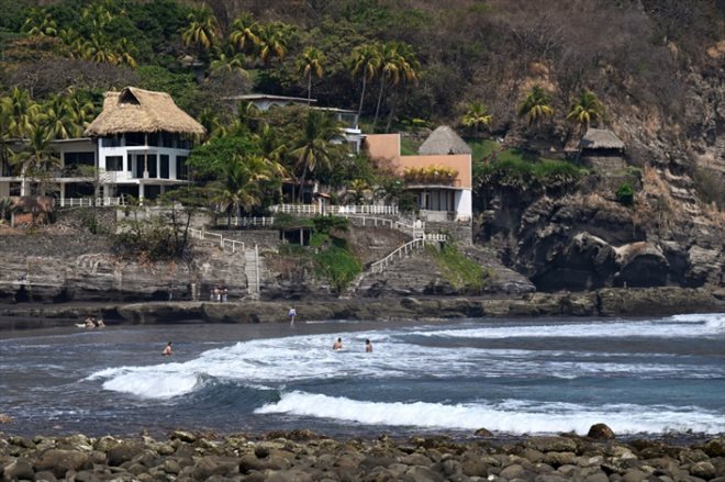 Des touristes se baignent sur la plage d'El Zonte, l'un des endroits où l'utilisation du bitcoin a été la plus encouragée, le 16 mars 2024 au Salvador 